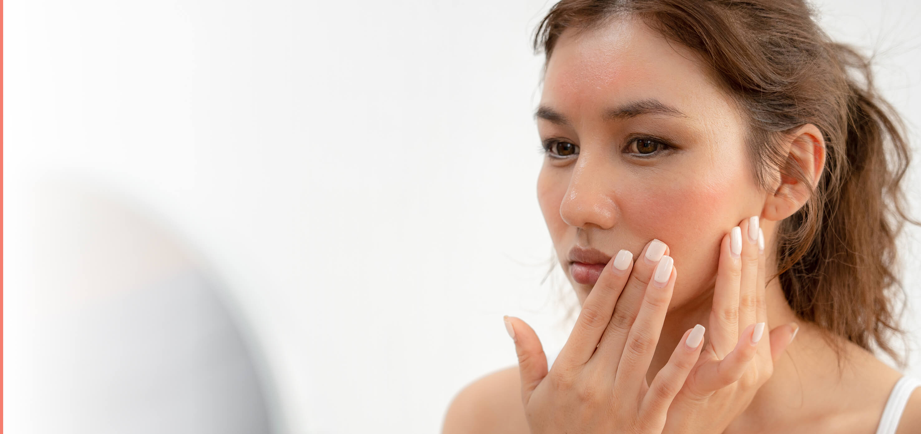 Patient examining skin concerns before seeking care at Coral Dermatology